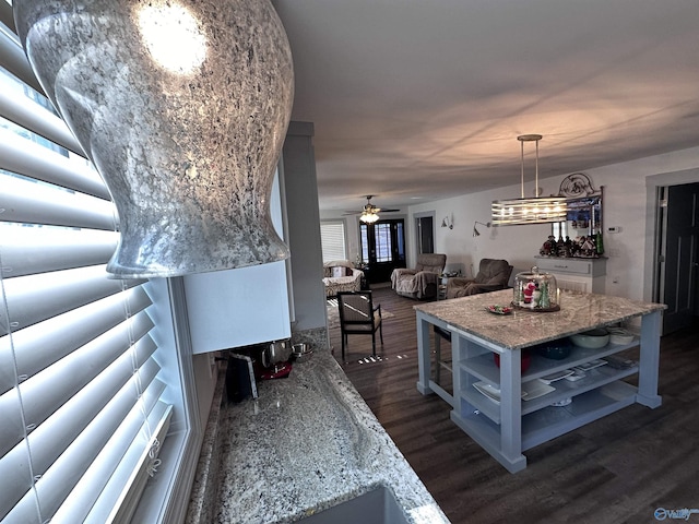 kitchen with ceiling fan, dark wood-type flooring, and decorative light fixtures