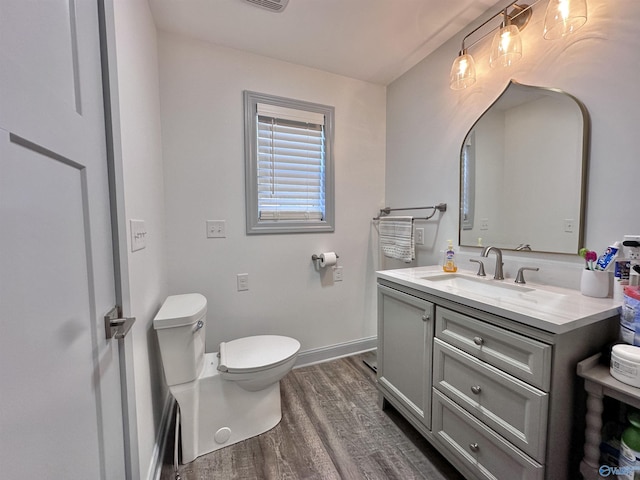 bathroom featuring hardwood / wood-style flooring, vanity, and toilet