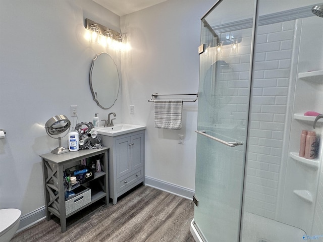 bathroom with vanity, hardwood / wood-style flooring, toilet, and a shower with shower door