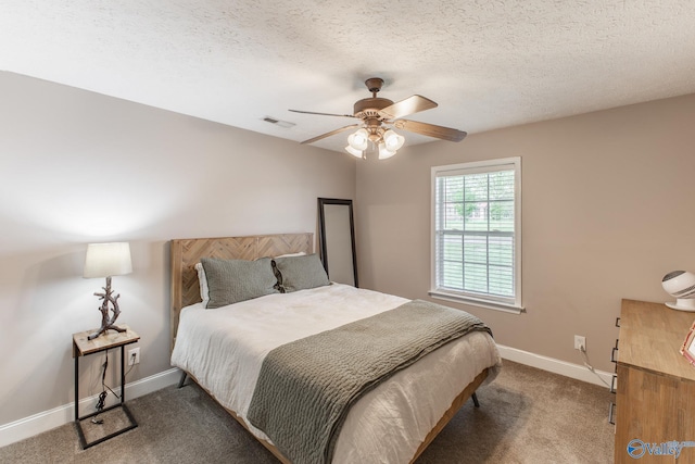bedroom with carpet, ceiling fan, baseboards, visible vents, and a textured ceiling