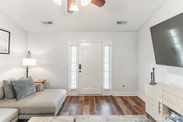 living area featuring a ceiling fan, visible vents, wood finished floors, and baseboards