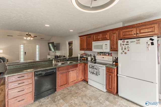kitchen with white appliances, dark countertops, a sink, a ceiling fan, and a textured ceiling