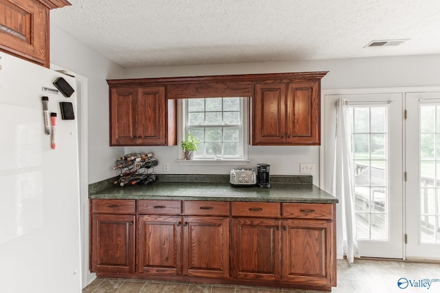 kitchen with visible vents, dark countertops, and a textured ceiling