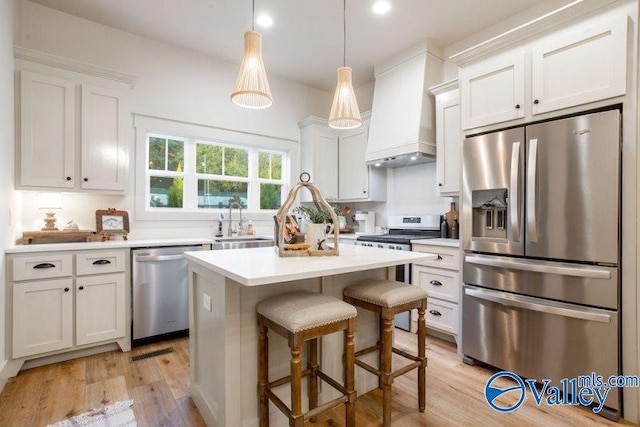 kitchen featuring custom exhaust hood, stainless steel appliances, light countertops, a sink, and a kitchen island