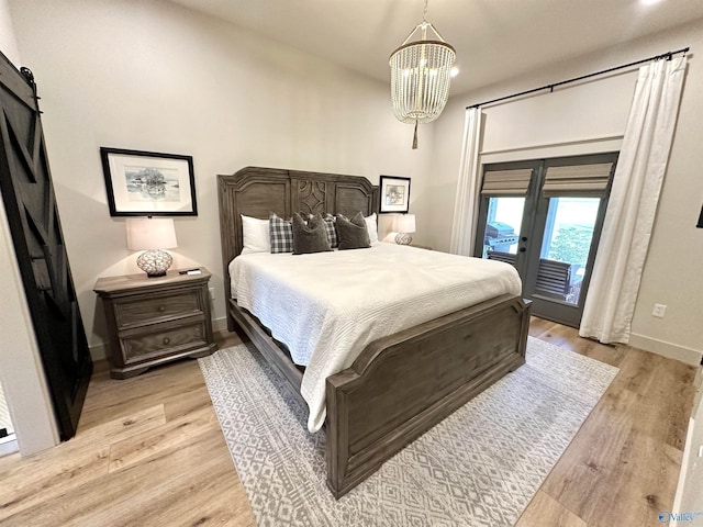 bedroom featuring access to outside, light wood-style flooring, baseboards, and an inviting chandelier