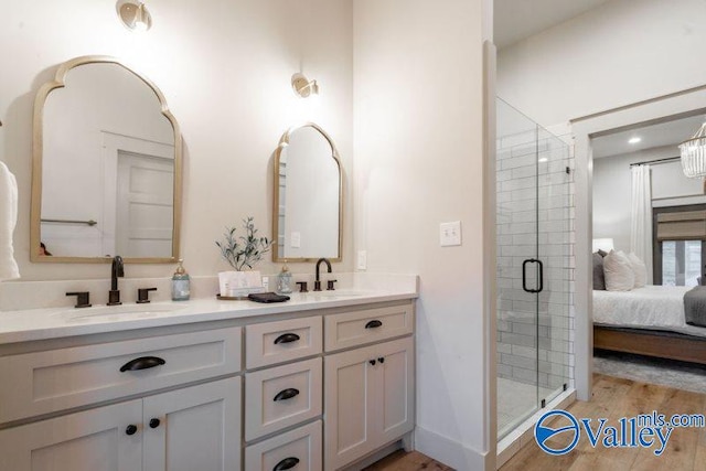 ensuite bathroom with double vanity, ensuite bath, a sink, and a stall shower