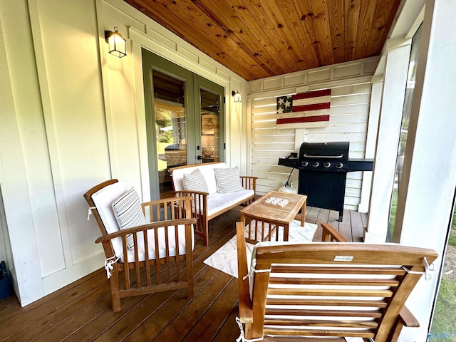 wooden terrace with grilling area and an outdoor hangout area