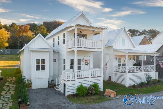 view of front of property with covered porch, metal roof, board and batten siding, and a balcony