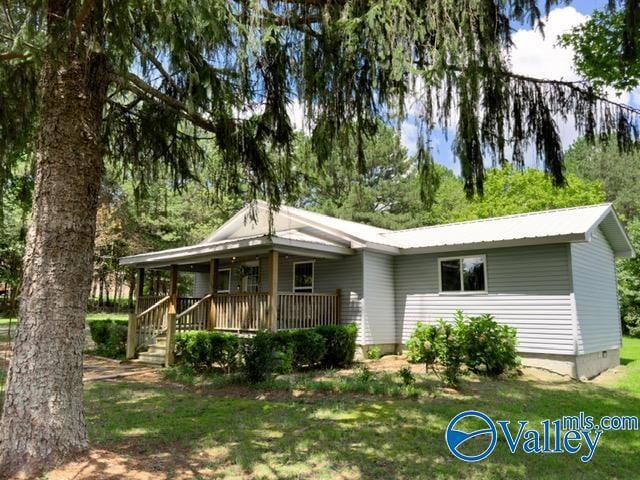 rear view of property with covered porch and a yard