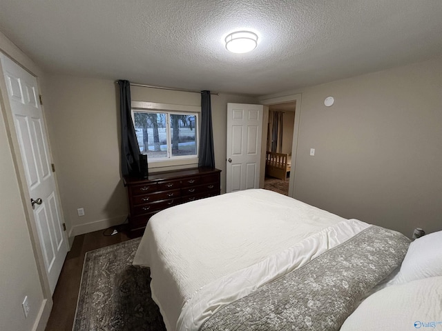 bedroom with dark wood-type flooring and a textured ceiling