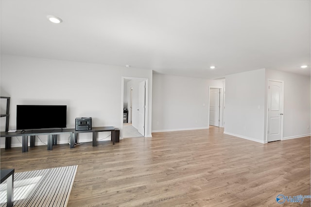 living room with light wood-style floors, recessed lighting, and baseboards