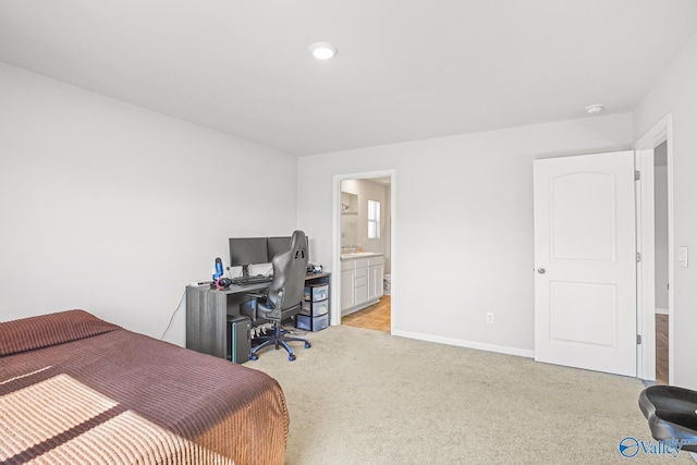 bedroom featuring baseboards, connected bathroom, and light colored carpet