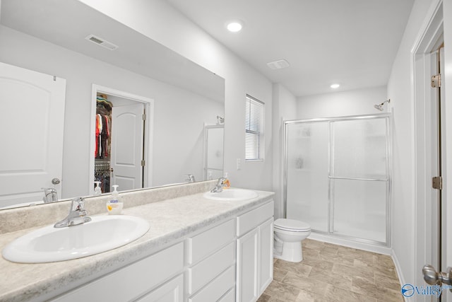 full bath featuring double vanity, a stall shower, a sink, and visible vents