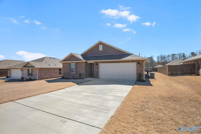 view of front of property with a garage, concrete driveway, brick siding, and fence