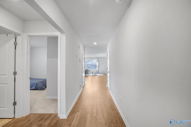 hallway featuring baseboards and wood finished floors