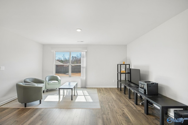 sitting room featuring wood finished floors, visible vents, and baseboards