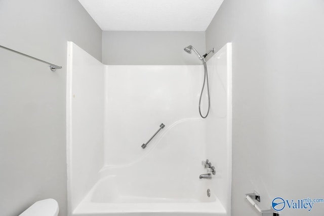 full bathroom featuring toilet, a textured ceiling, and  shower combination