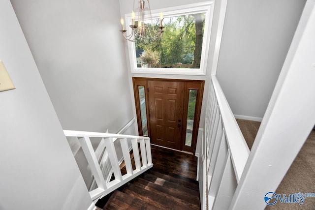 foyer featuring an inviting chandelier and wood finished floors