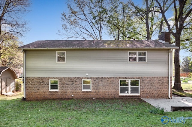 rear view of property featuring a chimney, a shed, an outdoor structure, and a lawn