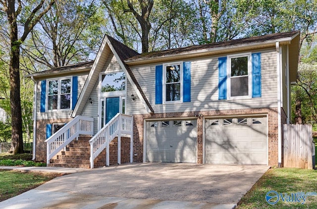 split foyer home featuring an attached garage, concrete driveway, and brick siding
