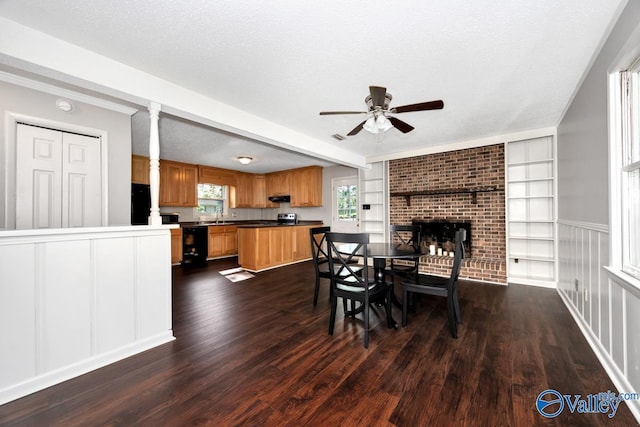 dining area featuring built in features, dark wood-type flooring, a textured ceiling, and a ceiling fan
