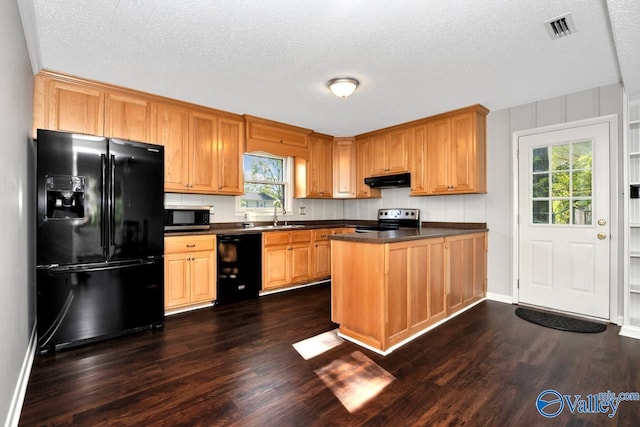 kitchen with a peninsula, dark countertops, a wealth of natural light, visible vents, and black appliances