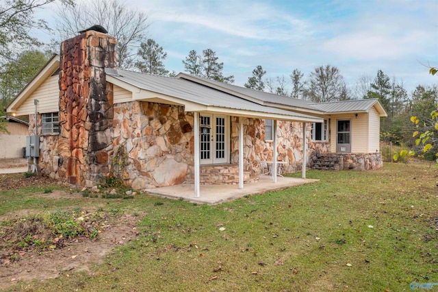 back of house with a yard and a patio