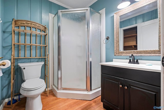 bathroom with walk in shower, ornamental molding, vanity, hardwood / wood-style flooring, and toilet