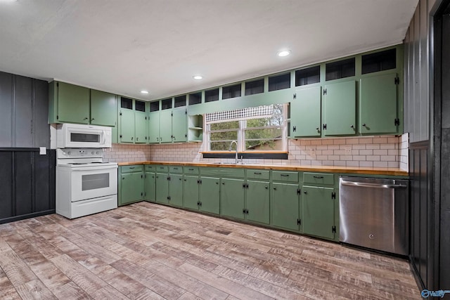 kitchen featuring white appliances, light hardwood / wood-style floors, green cabinets, and sink