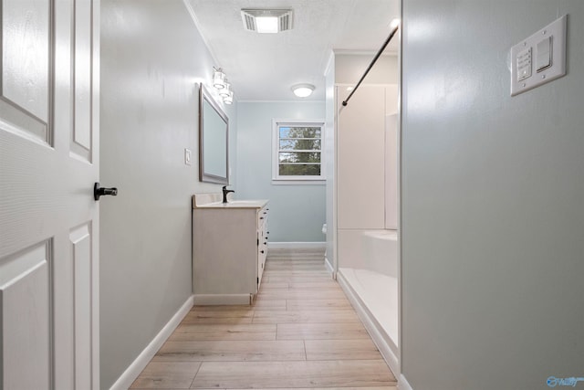 bathroom featuring vanity, crown molding, toilet, walk in shower, and wood-type flooring