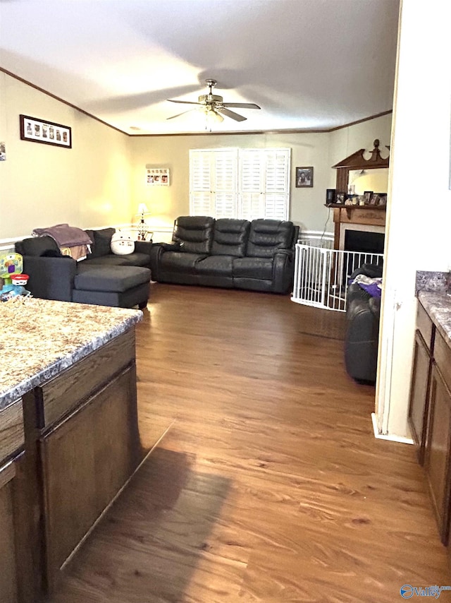 living room with ceiling fan, wood finished floors, and ornamental molding