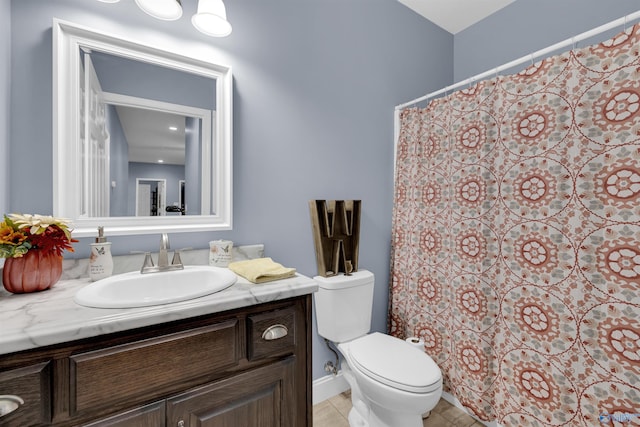 bathroom with toilet, vanity, and tile patterned floors