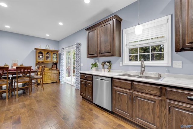 kitchen featuring dark wood-type flooring, sink, stainless steel dishwasher, dark brown cabinets, and pendant lighting