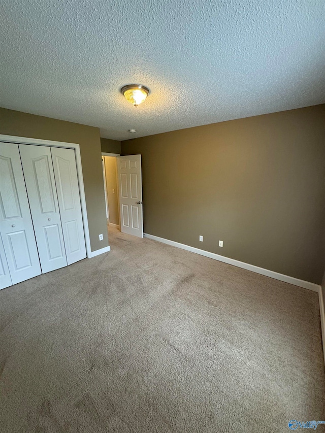 unfurnished bedroom featuring a closet, carpet flooring, and a textured ceiling