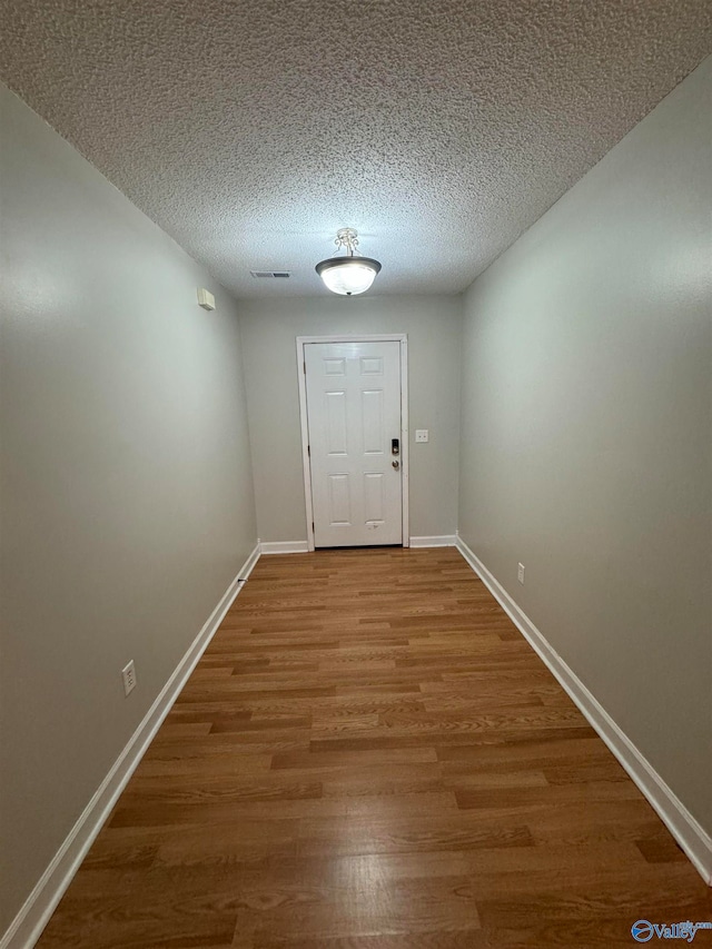 doorway to outside with hardwood / wood-style flooring and a textured ceiling