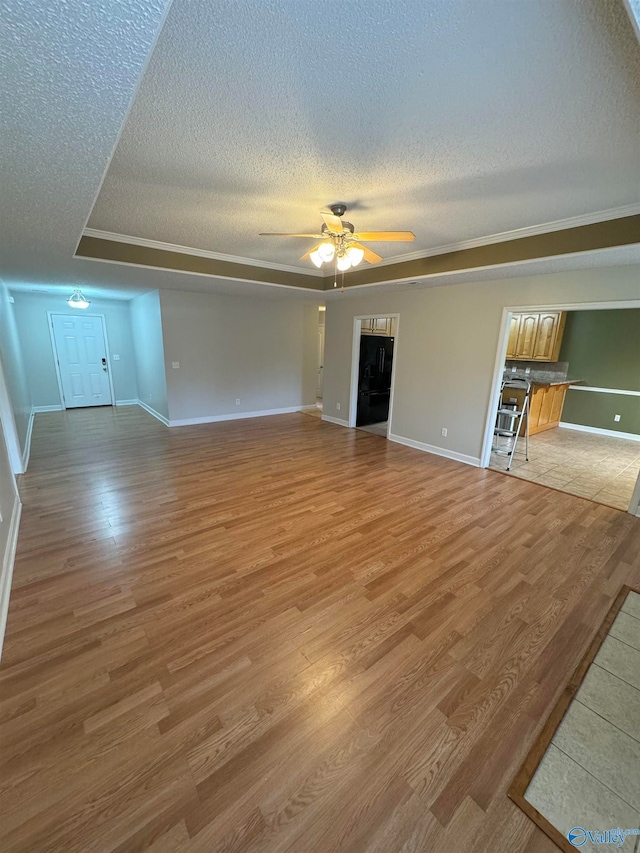 unfurnished living room featuring ceiling fan, a textured ceiling, and light hardwood / wood-style flooring