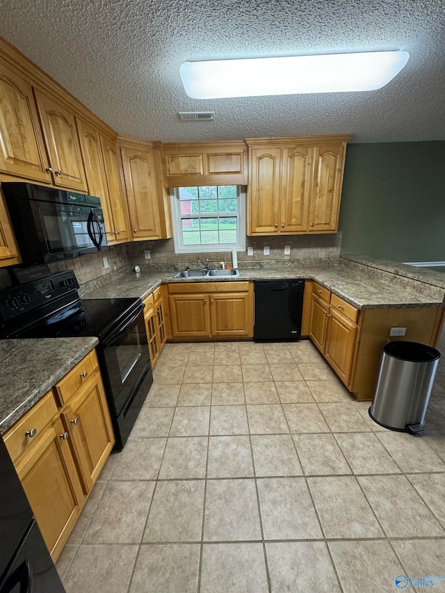 kitchen with light tile patterned floors, sink, a textured ceiling, backsplash, and black appliances