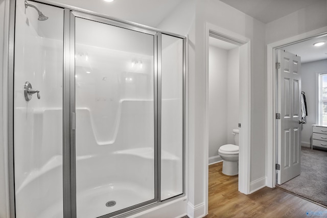 16821 Demi Dr, Athens, AL 35613 - bathroom with a stall shower, wood finished floors, baseboards, and toilet