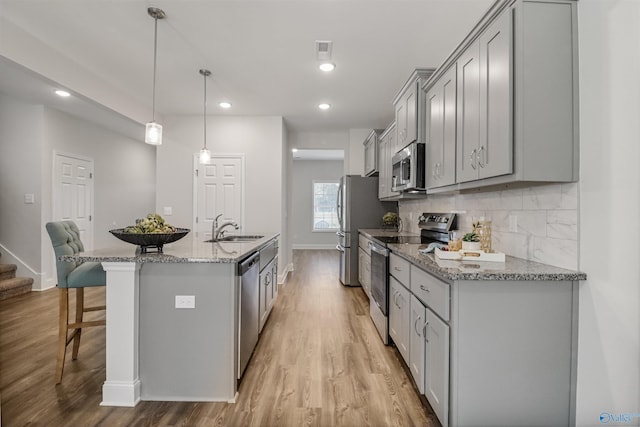 16821 Demi Dr, Athens, AL 35613 - kitchen with appliances with stainless steel finishes, a sink, gray cabinets, a kitchen bar, and baseboards