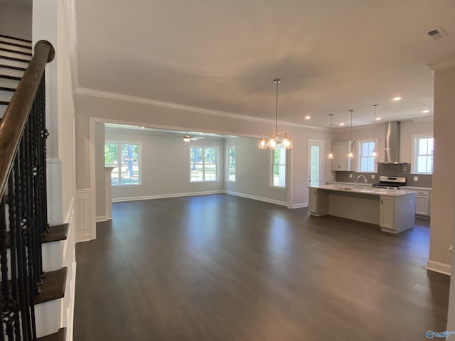 unfurnished living room with sink, ornamental molding, dark hardwood / wood-style floors, and ceiling fan with notable chandelier