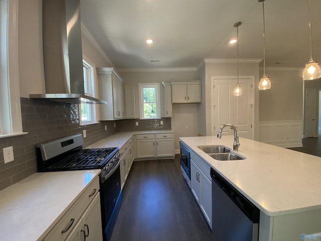 kitchen with sink, a center island with sink, pendant lighting, stainless steel appliances, and wall chimney range hood