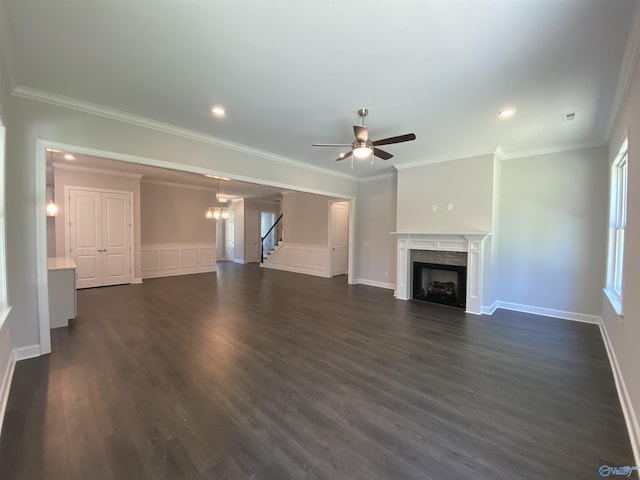 unfurnished living room with dark hardwood / wood-style flooring, ceiling fan with notable chandelier, and ornamental molding