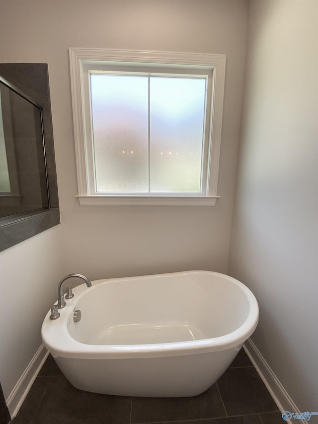 bathroom with tile patterned flooring and a washtub