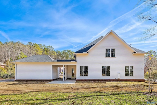 back of property with a lawn and a patio area