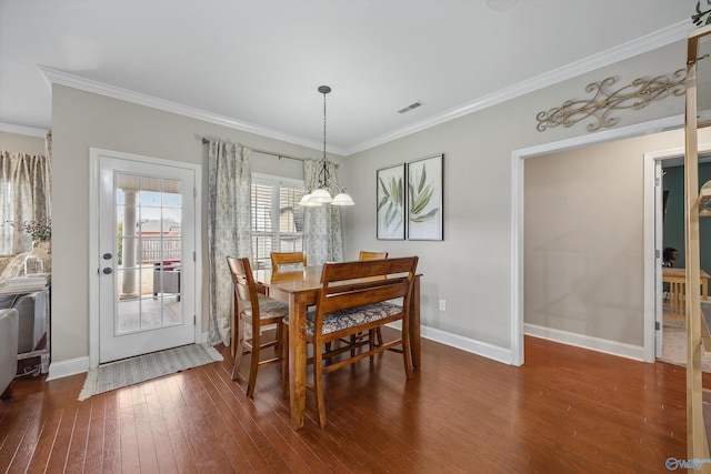 dining space with baseboards, wood-type flooring, visible vents, and crown molding