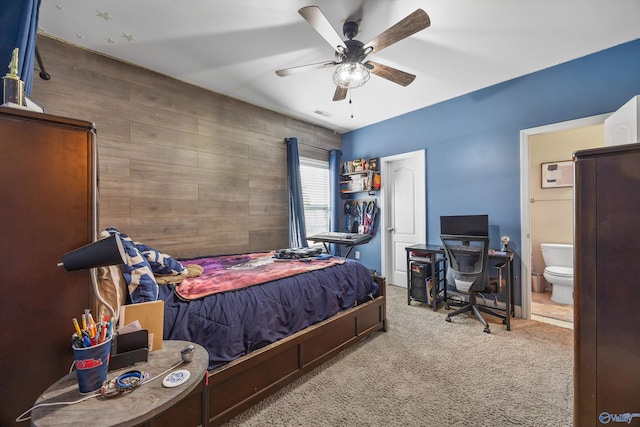 bedroom featuring visible vents, carpet floors, ensuite bath, and wood walls