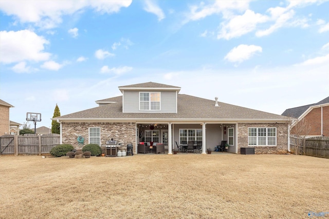 rear view of property featuring a patio, a lawn, and a fenced backyard