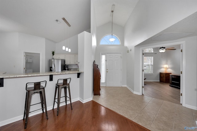 entrance foyer featuring ceiling fan, light hardwood / wood-style floors, and high vaulted ceiling