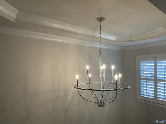 room details with a tray ceiling, a chandelier, and ornamental molding