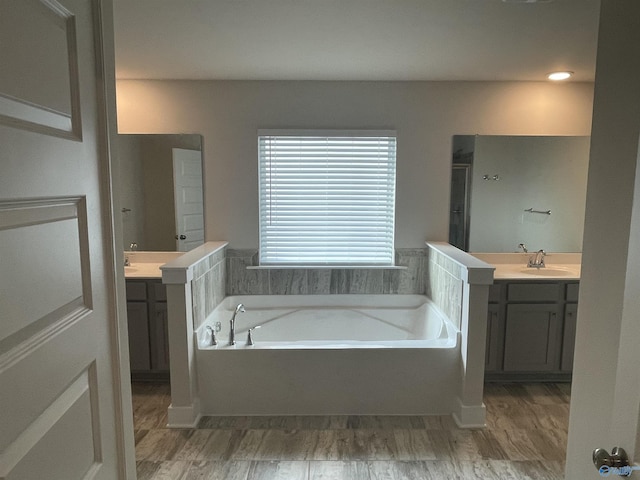 bathroom featuring hardwood / wood-style flooring, vanity, and a bath